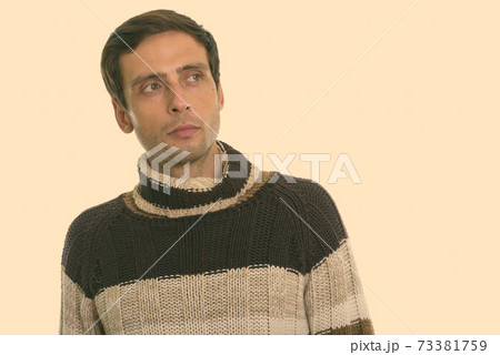 Studio shot of young handsome man thinking while looking up 73381759