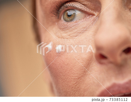 Close up of female face with eye cream 73385112