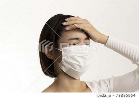 マスク姿の女性/頭痛/風邪の症状/熱の症状/白い服/	 73385954