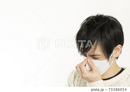 マスク姿の男性/頭痛で頭を抱える/具合が悪い独身男性/ マスク姿の男性/頭痛で頭を抱える/具合が悪い独身男性/ 73386054