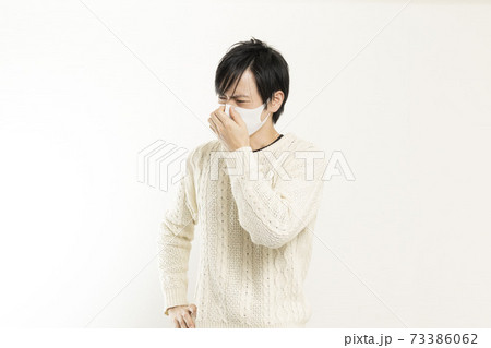 マスク姿の男性/頭痛で頭を抱える/具合が悪い独身男性/ マスク姿の男性/頭痛で頭を抱える/具合が悪い独身男性/ 73386062