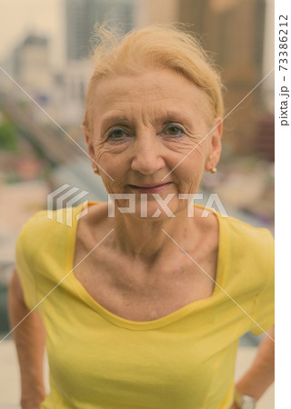 Beautiful senior woman with blond hair against view of the city Beautiful senior woman with blond hair against view of the city 73386212