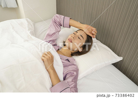 病気で寝込んでいる女性/体調の悪い女性/ベットに寝ている美しい女性 73386402