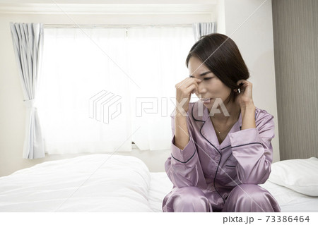病気で寝込んでいる女性/体調の悪い女性/ベットに寝ている美しい女性/ベッドに座っている美人 病気で寝込んでいる女性/体調の悪い女性/ベットに寝ている美しい女性/ベッドに座っている美人 73386464
