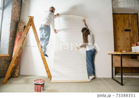 Young family doing apartment repair together themselves. Married man and woman doing home makeover or renovation 73388351