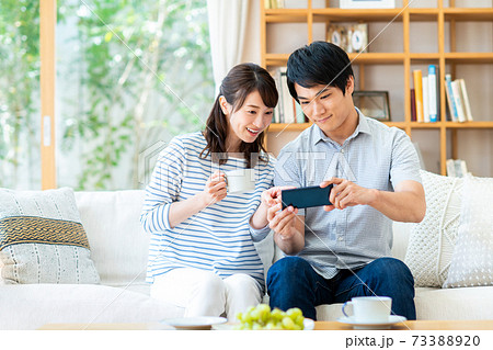 スマホで動画を見る若い夫婦の写真素材 7330