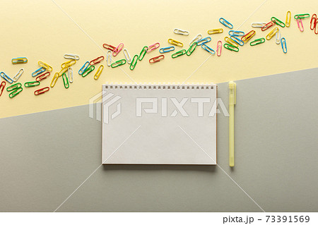 Open spiral notepad on gray and yellow background Open spiral notepad on gray and yellow background 73391569