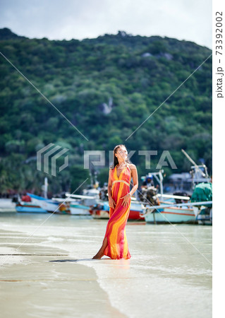 Sexy girl i long dress posing on the tropical beach 73392002