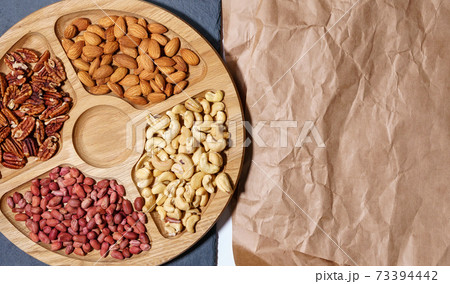 Cashews, pecans, peanuts, almonds. Various nuts on the stone table. Top view with space to copy. 73394442
