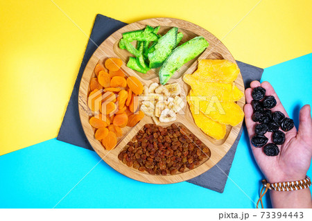 dried fruits on a colored background Flat lay. mango, raisins, papaya, bananas, dried apricots. Healthy vegetarian food. 73394443