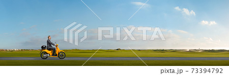 office worker or businessman sits and goes on motor scooter outdoor office worker or businessman sits and goes on motor scooter outdoor 73394792