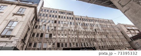 Intentionally tilted panorama of an ugly office tower 73395332