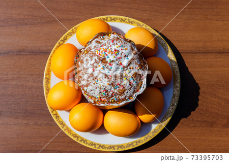 Easter cake and painted eggs on a table Easter cake and painted eggs on a table 73395703