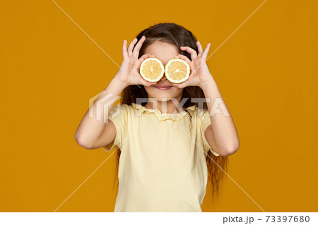 cute little child girl holding fresh juicy lemon cute little child girl holding fresh juicy lemon 73397680