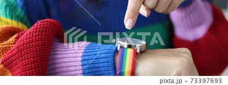 Woman in an lgbt sweater points her finger at clock face. Woman in an lgbt sweater points her finger at clock face. 73397693