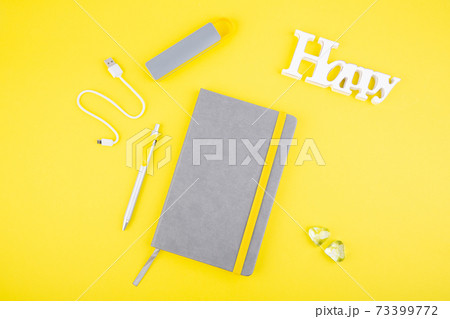 Gray notebook with handle and external battery on yellow background 73399772