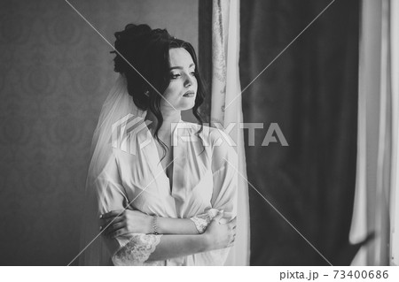 Luxury bride in white dress posing while preparing for the wedding ceremony 73400686