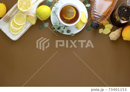 Black tea with lemon, honey and ginger on a brown table, copy space. 73401153