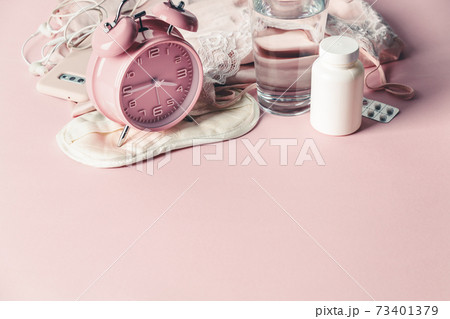 Alarm clock, eye mask, pills and glass of water on pink background. Insomnia or depression treatment for sleepless nights, copy space Alarm clock, eye mask, pills and glass of water on pink background. Insomnia or depression treatment for sleepless nights, copy space 73401379