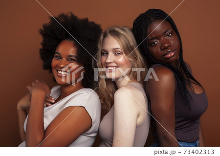 young pretty caucasian, afro, scandinavian woman posing cheerful together on brown background, lifestyle diverse nationality people concept young pretty caucasian, afro, scandinavian woman posing cheerful together on brown background, lifestyle diverse nationality people concept 73402313