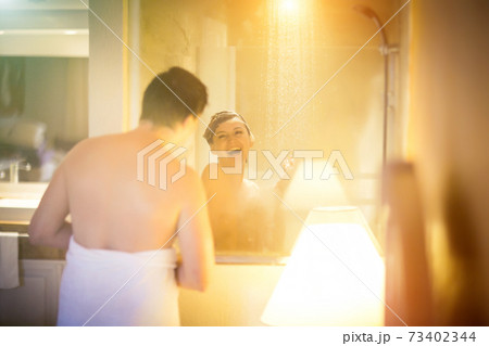 soft focus.man with towel in front of woman take shower in bathroom with window soft focus.man with towel in front of woman take shower in bathroom with window 73402344