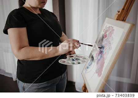 Young concentrated woman do easel drawing 73403839