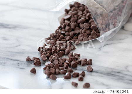 袋から出して大理石に散りばめたチョコレートチップ 73405041