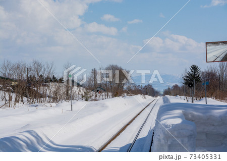冬の田舎の無人駅と線路 73405331