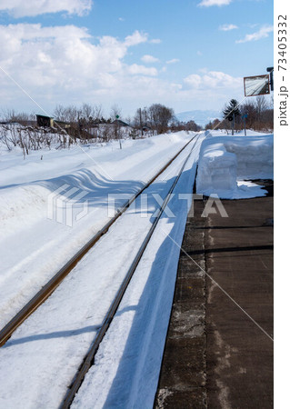 冬の田舎の無人駅と線路 73405332