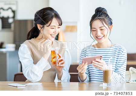 カフェで動画を見る若い女性 73407853