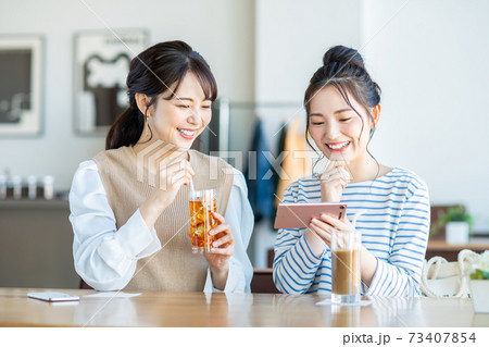 カフェで動画を見る若い女性 カフェで動画を見る若い女性 73407854