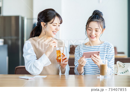カフェで動画を見る若い女性 カフェで動画を見る若い女性 73407855