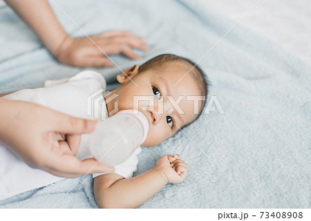 Little newborn baby boy sleep and drinking milk on a comfortable bed in the morning 73408908