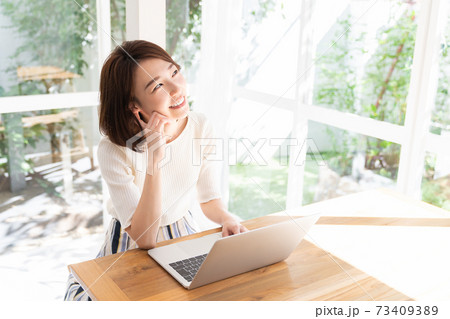 部屋でラップトップコンピューターを見る女性 部屋でラップトップコンピューターを見る女性 73409389