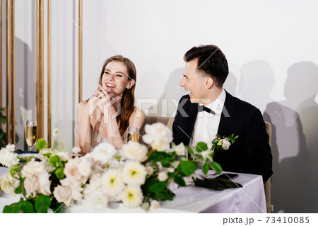 newlyweds listen to toasts, congratulations from guests and laugh newlyweds listen to toasts, congratulations from guests and laugh 73410085