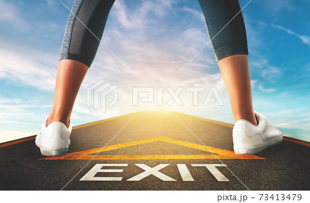 Woman standing on exit signage road for Business exit strategy concept with blue sky background. Woman standing on exit signage road for Business exit strategy concept with blue sky background. 73413479