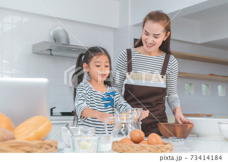 Happy Asian Mother and daughter is making flour for Bakery and bread in home kitchen for parenting concept. Happy Asian Mother and daughter is making flour for Bakery and bread in home kitchen for parenting concept. 73414184