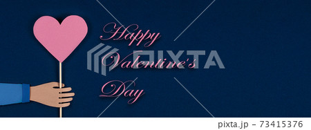 Hand holding a Paper Origami Heart with inscription Happy Valentines Day. Hand holding a Paper Origami Heart with inscription Happy Valentines Day. 73415376