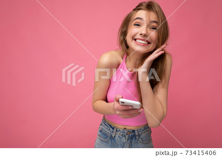 Charming overjoyed young blonde woman wearing pink top poising isolated on pink background with Charming overjoyed young blonde woman wearing pink top poising isolated on pink background with 73415406