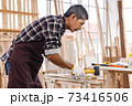 Asian senior man using wallet in woodwork at carpentry workshop. Concept senior people doing hobby after retirement. 73416506