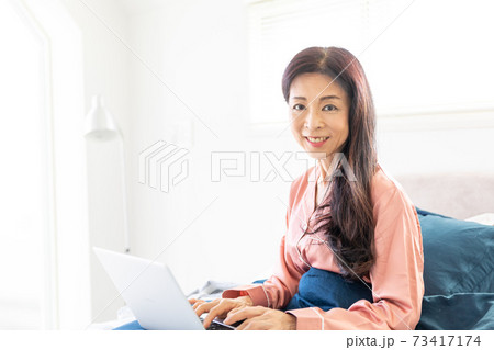 ベッドでパソコンをする女性 ベッドでパソコンをする女性 73417174