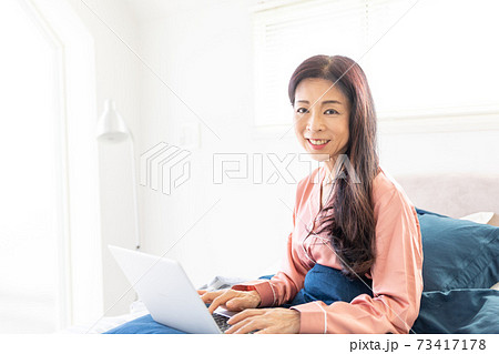 ベッドでパソコンをする女性 ベッドでパソコンをする女性 73417178