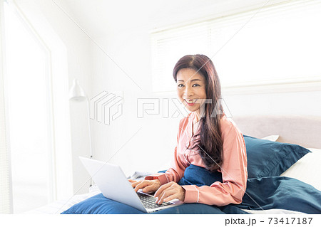 ベッドでパソコンをする女性 73417187
