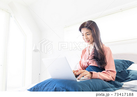 ベッドでパソコンをする女性 ベッドでパソコンをする女性 73417188