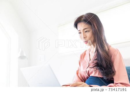ベッドでパソコンをする女性 ベッドでパソコンをする女性 73417191