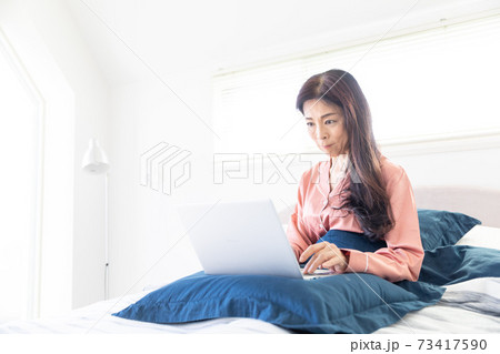 ベッドでパソコンをする女性 ベッドでパソコンをする女性 73417590