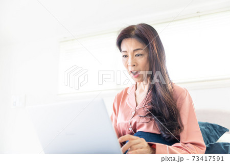 ベッドでパソコンをする女性 73417591