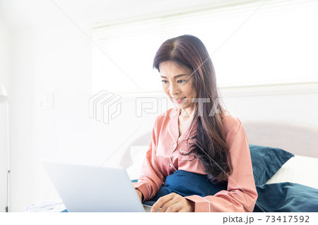 ベッドでパソコンをする女性 73417592