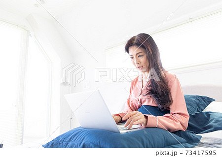 ベッドでパソコンをする女性 73417595