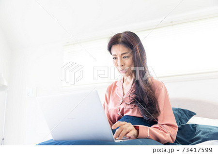 ベッドでパソコンをする女性 ベッドでパソコンをする女性 73417599